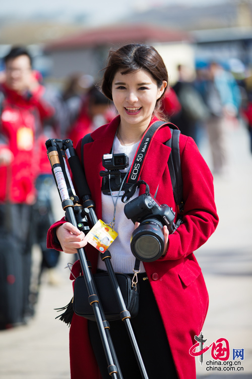 2016年兩會，人民大會大堂前，一位笑容燦爛的紅衣女記者正步入大會堂。中國網(wǎng) 鄭亮 攝